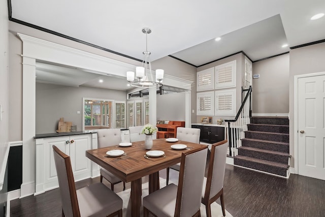 dining area featuring dark hardwood / wood-style floors, crown molding, and an inviting chandelier