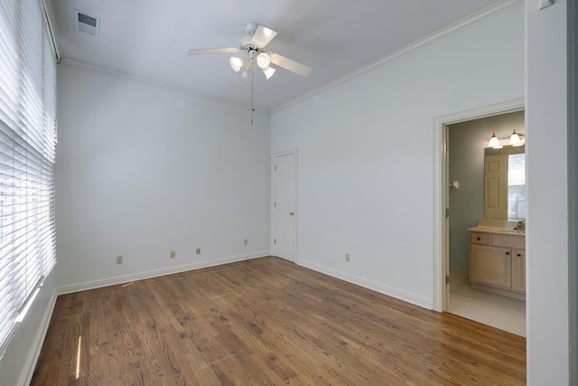 empty room featuring a wealth of natural light, crown molding, ceiling fan, and dark wood-type flooring