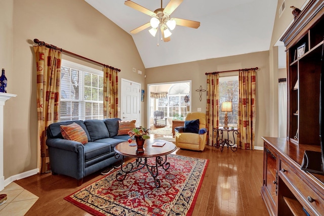 living room featuring dark hardwood / wood-style flooring, high vaulted ceiling, ceiling fan, and a healthy amount of sunlight