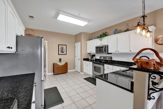 kitchen featuring hanging light fixtures, stainless steel appliances, tasteful backsplash, white cabinets, and light tile patterned flooring