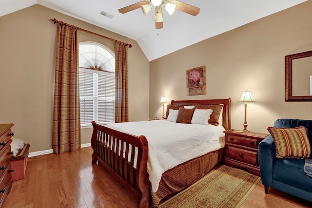 bedroom with multiple windows, hardwood / wood-style flooring, ceiling fan, and lofted ceiling