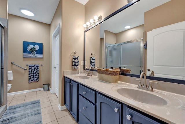 bathroom featuring tile patterned flooring, vanity, a shower with shower door, and toilet