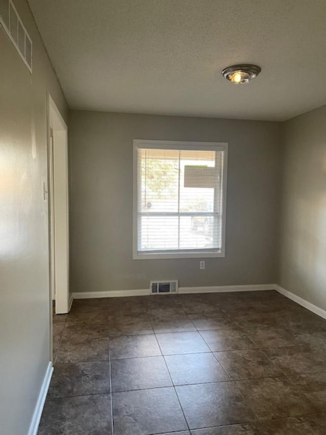 unfurnished room with a textured ceiling