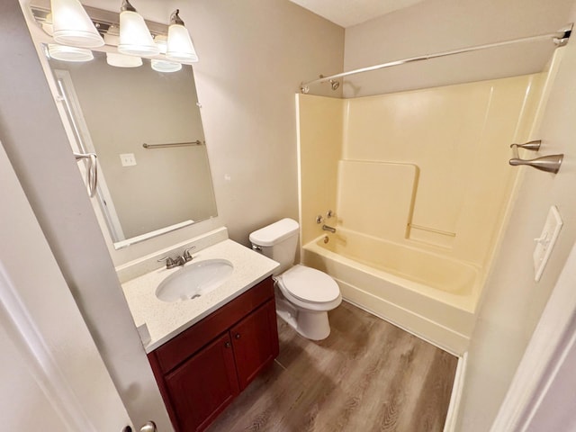 full bathroom with toilet, vanity,  shower combination, and hardwood / wood-style flooring