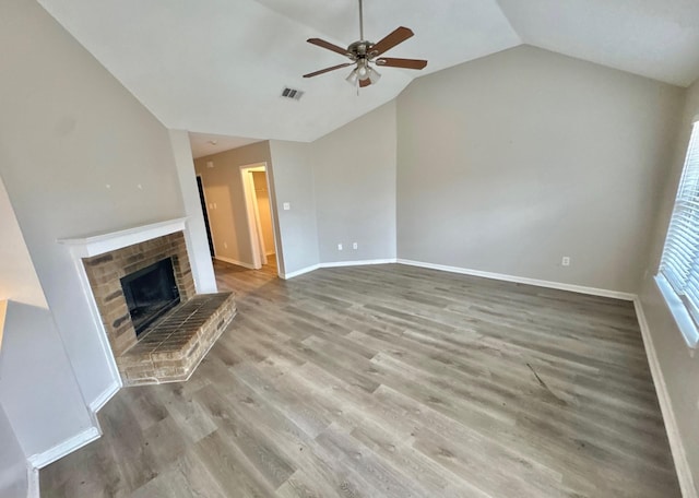 unfurnished living room featuring ceiling fan, light hardwood / wood-style floors, a fireplace, and vaulted ceiling