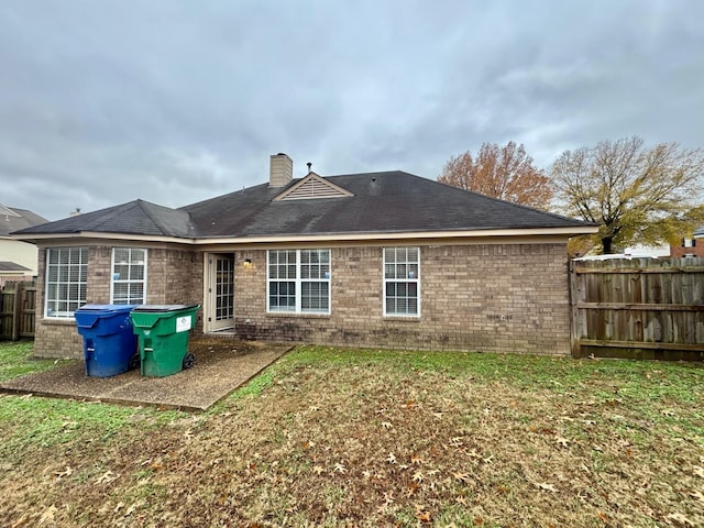 back of house featuring a lawn