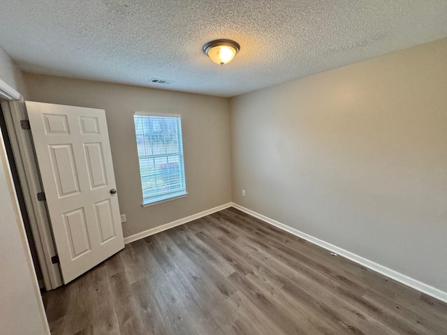 empty room featuring hardwood / wood-style floors and a textured ceiling