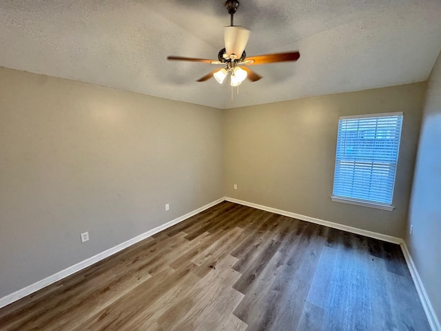 empty room featuring ceiling fan, a textured ceiling, and hardwood / wood-style flooring