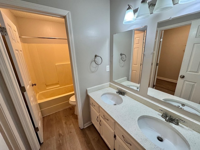 full bathroom featuring washtub / shower combination, toilet, vanity, and hardwood / wood-style flooring