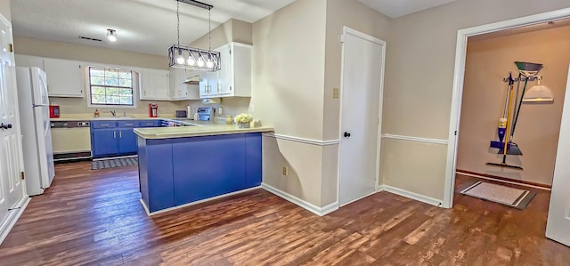 kitchen featuring pendant lighting, white appliances, dark hardwood / wood-style floors, a textured ceiling, and white cabinetry