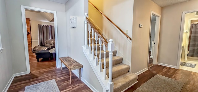 stairway featuring hardwood / wood-style floors and a textured ceiling