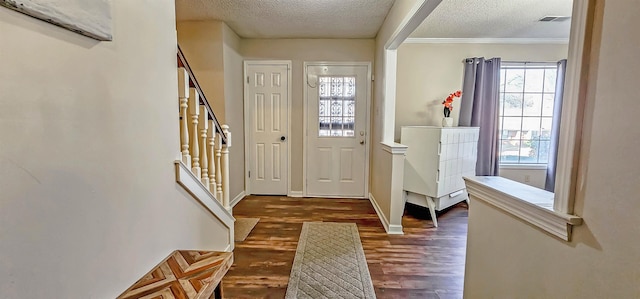 entryway featuring dark hardwood / wood-style flooring, a textured ceiling, and crown molding