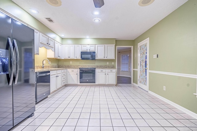 kitchen with black appliances, white cabinets, light tile patterned floors, and sink