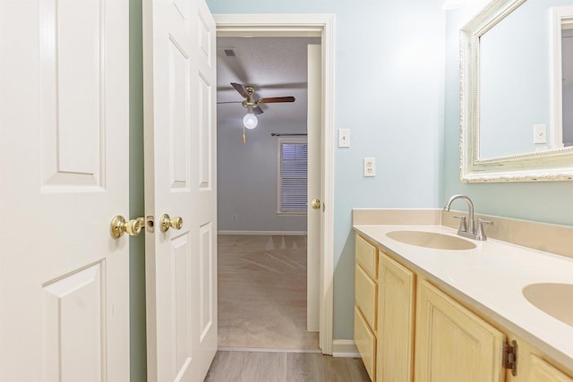 bathroom with ceiling fan, a textured ceiling, and vanity