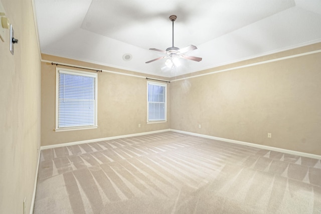 carpeted empty room with ceiling fan, a raised ceiling, crown molding, and vaulted ceiling