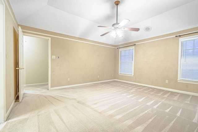 spare room featuring light colored carpet, vaulted ceiling, ceiling fan, and ornamental molding