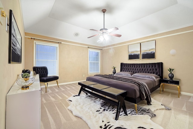 bedroom featuring a tray ceiling, ceiling fan, light carpet, and lofted ceiling