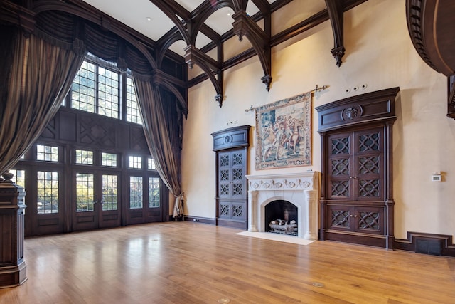 unfurnished living room featuring a high ceiling and hardwood / wood-style floors