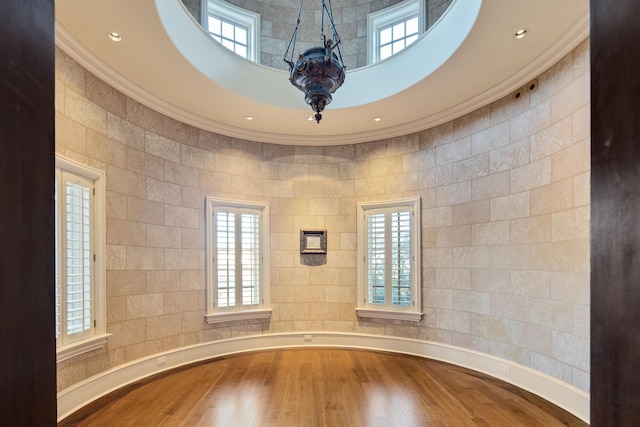 interior space featuring crown molding, tile walls, and hardwood / wood-style flooring