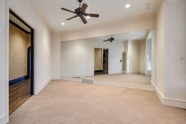 carpeted empty room with crown molding and ceiling fan