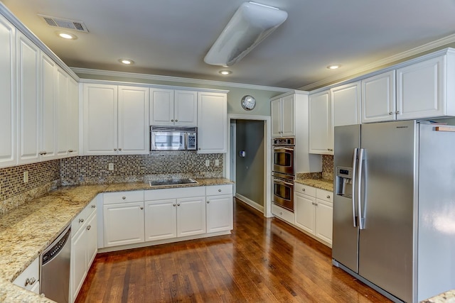 kitchen featuring light stone counters, dark hardwood / wood-style flooring, decorative backsplash, white cabinets, and appliances with stainless steel finishes