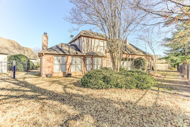 rear view of property featuring a lawn