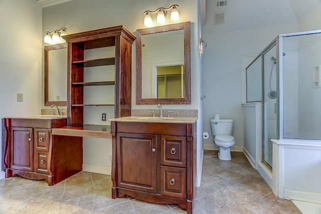 bathroom featuring vanity, toilet, and a shower with shower door