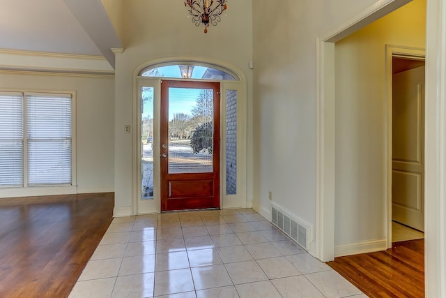 tiled foyer entrance featuring a chandelier