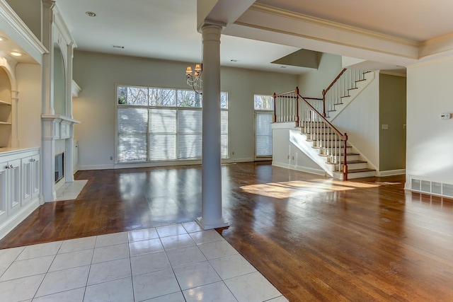 unfurnished living room featuring light tile patterned floors, an inviting chandelier, and ornamental molding