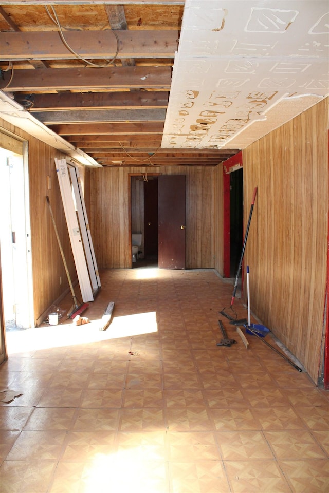 basement featuring parquet flooring and wooden walls