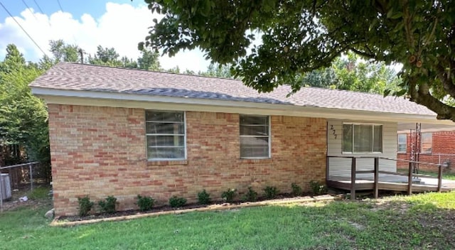 rear view of property with a deck and a yard