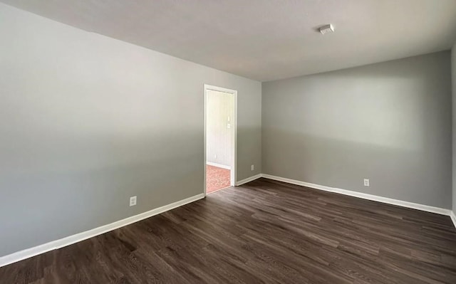 spare room featuring dark wood-type flooring