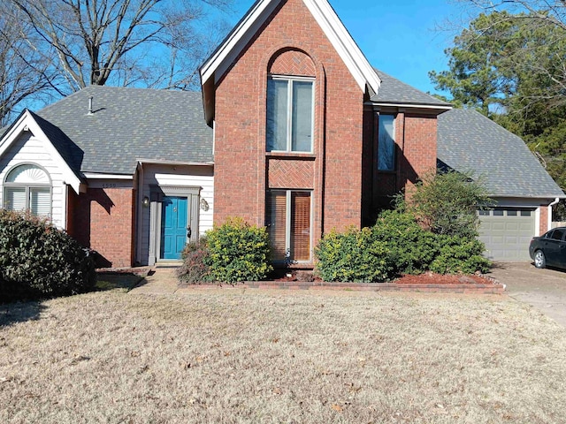 view of front of house with a front yard, brick siding, driveway, and an attached garage