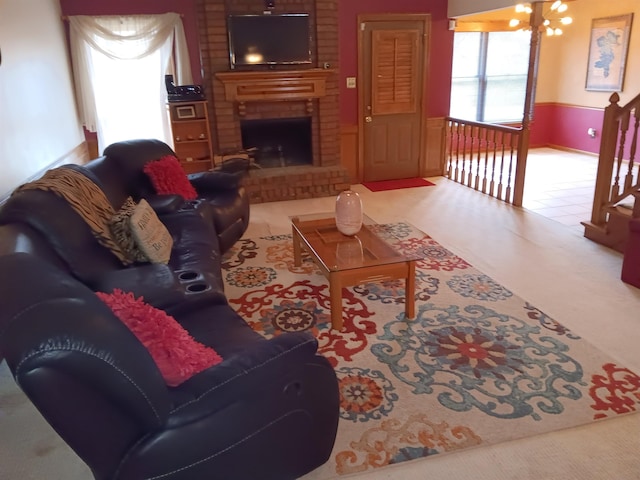 living room featuring an inviting chandelier and a brick fireplace