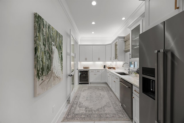 kitchen with backsplash, stainless steel appliances, sink, white cabinetry, and wine cooler