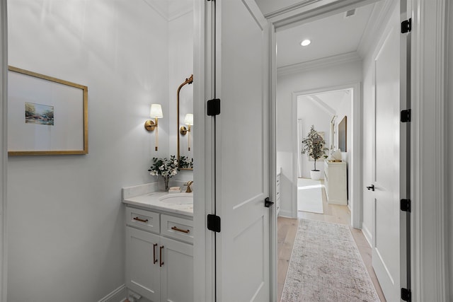 bathroom with hardwood / wood-style floors, vanity, and ornamental molding