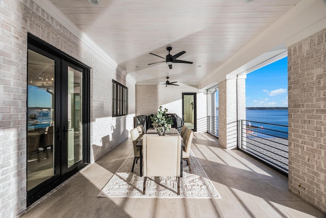 sunroom with french doors, a water view, and ceiling fan