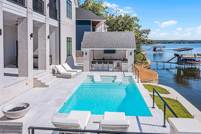 view of pool featuring a bar, a patio, and a water view