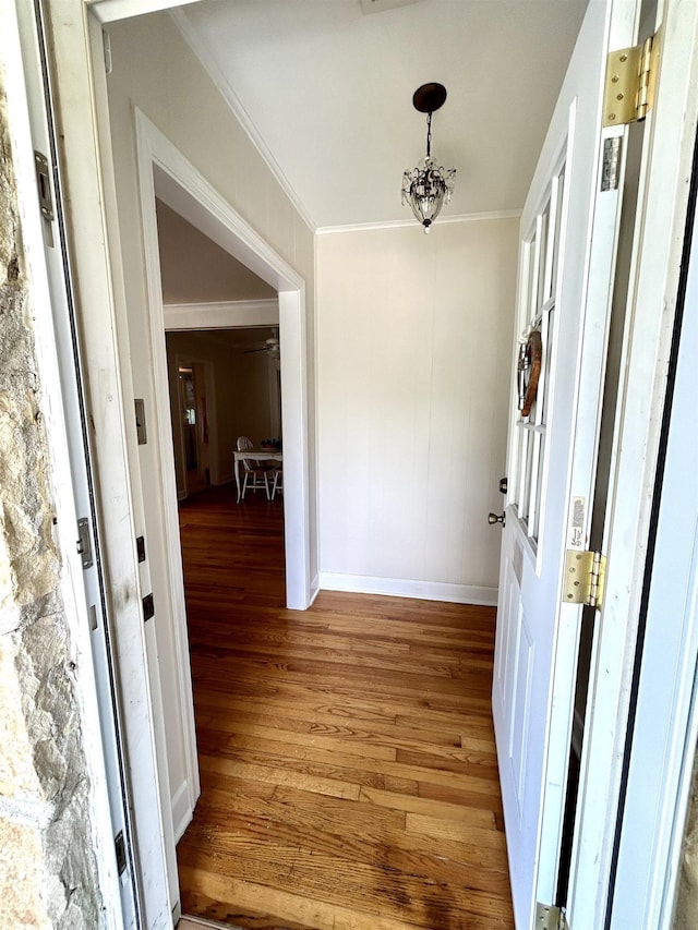 foyer with hardwood / wood-style floors, an inviting chandelier, and ornamental molding