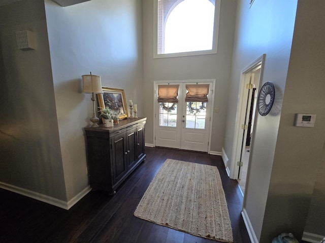 entrance foyer with dark hardwood / wood-style flooring, french doors, and a high ceiling