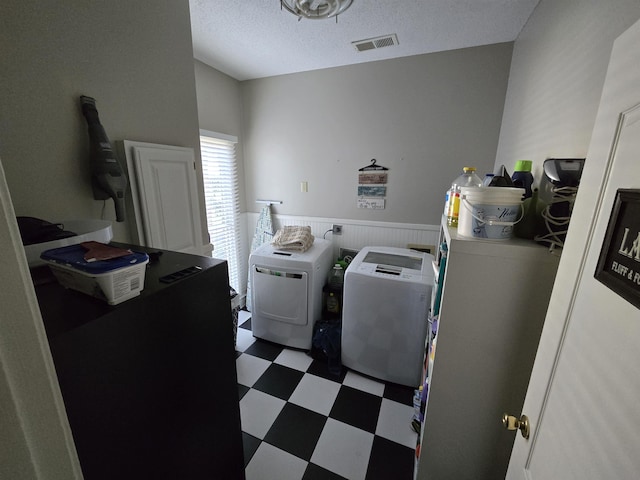 washroom with independent washer and dryer and a textured ceiling