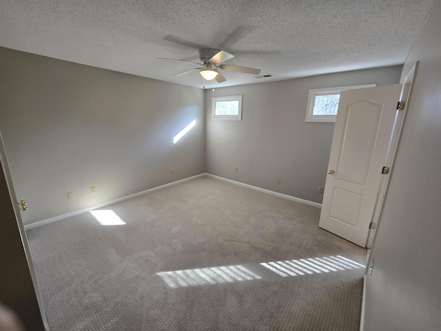 carpeted spare room with ceiling fan and a textured ceiling