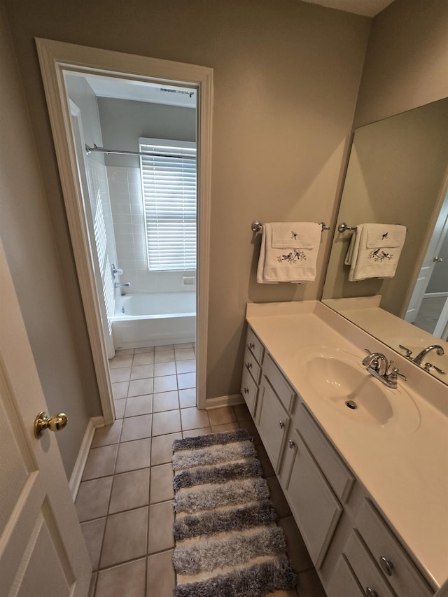 bathroom featuring tile patterned flooring, vanity, and tiled shower / bath