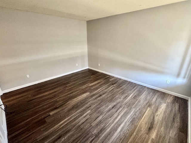 empty room with dark hardwood / wood-style flooring