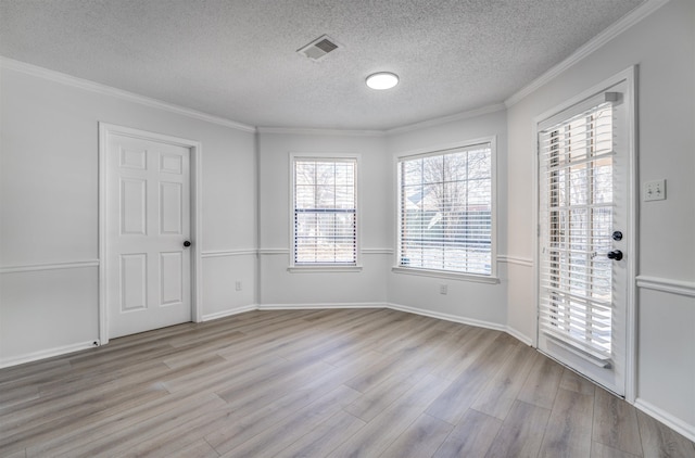 entryway featuring a textured ceiling, light wood-type flooring, and crown molding