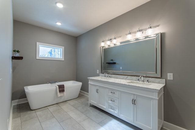 bathroom with tile patterned floors, a bathtub, and vanity