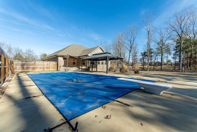 view of pool with a patio area and a diving board