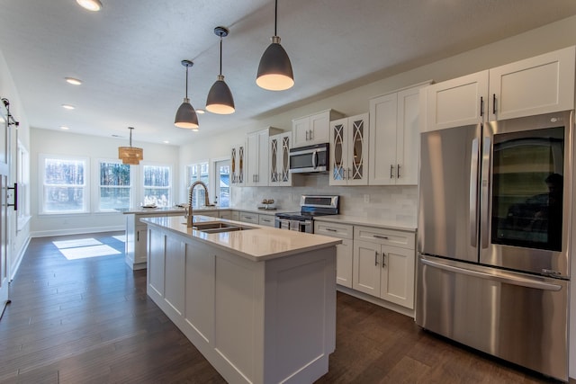 kitchen featuring white cabinets, hanging light fixtures, sink, and appliances with stainless steel finishes