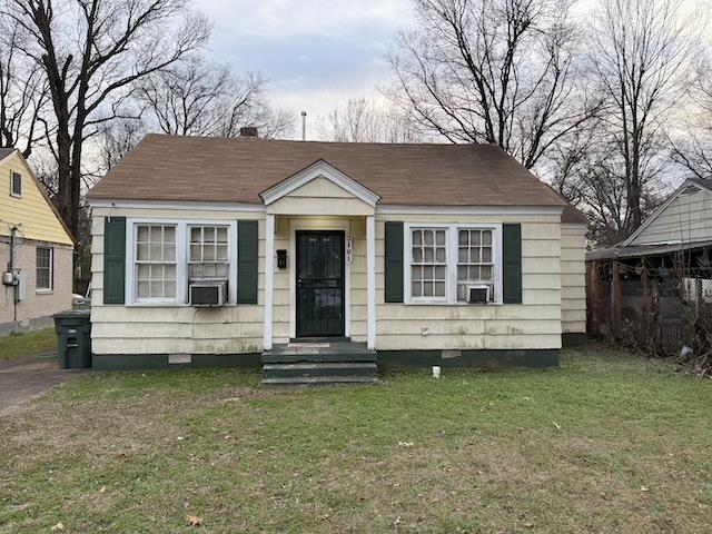 bungalow-style house with cooling unit and a front lawn