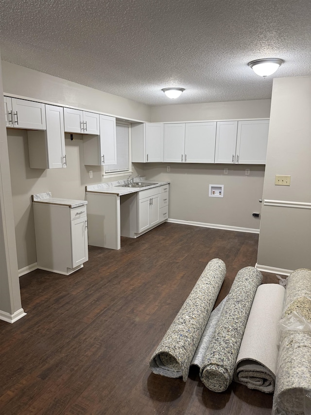 kitchen featuring sink, dark hardwood / wood-style flooring, white cabinetry, and a textured ceiling